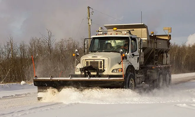Strathcona County equipment plowing a rural road.