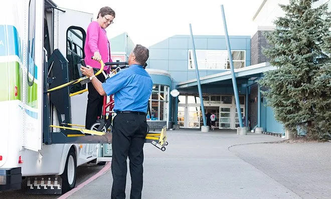 A passenger using the lift on a Strathcona County Mobility Bus.